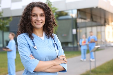 Photo of Medical student in uniform with stethoscope outdoors, selective focus