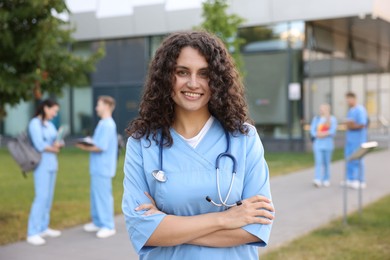 Photo of Medical student in uniform with stethoscope outdoors, selective focus