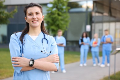 Photo of Medical student in uniform with stethoscope outdoors, selective focus