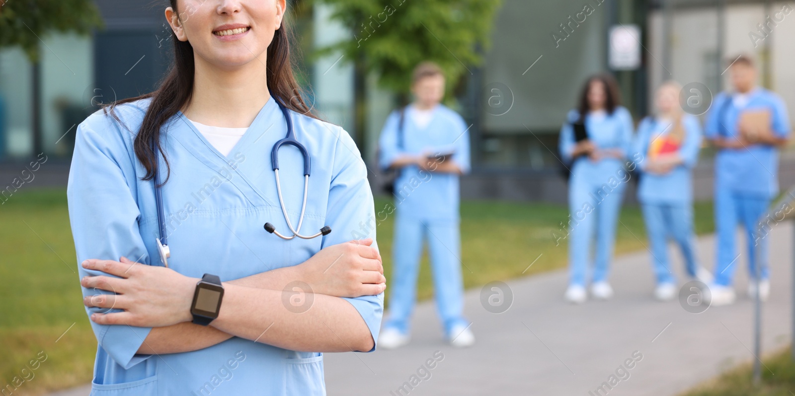 Medical student in uniform with stethoscope outdoors, selective focus Photo of Medical student in uniform with stethoscope outdoors, selective focus