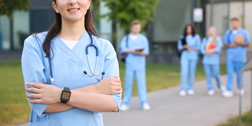 Photo of Medical student in uniform with stethoscope outdoors, selective focus