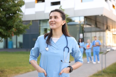Photo of Medical student in uniform with stethoscope outdoors, selective focus