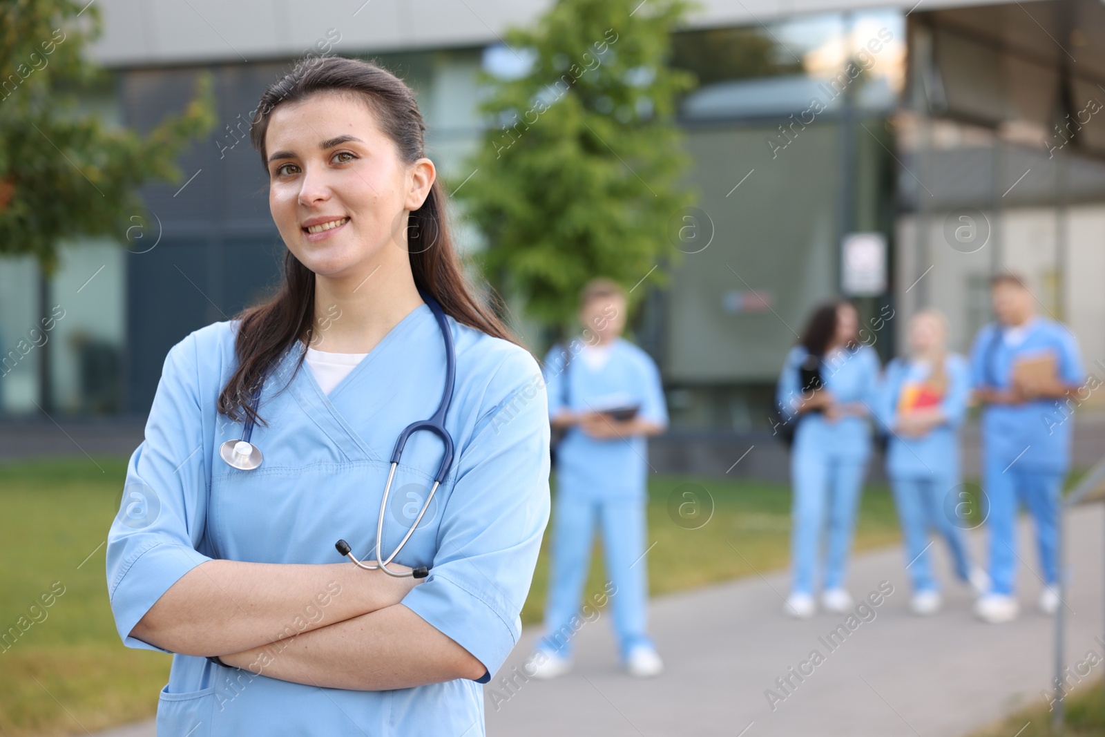 Medical student in uniform with stethoscope outdoors, selective focus Photo of Medical student in uniform with stethoscope outdoors, selective focus