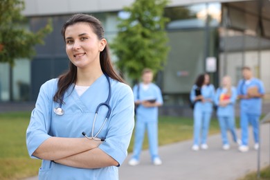 Photo of Medical student in uniform with stethoscope outdoors, selective focus