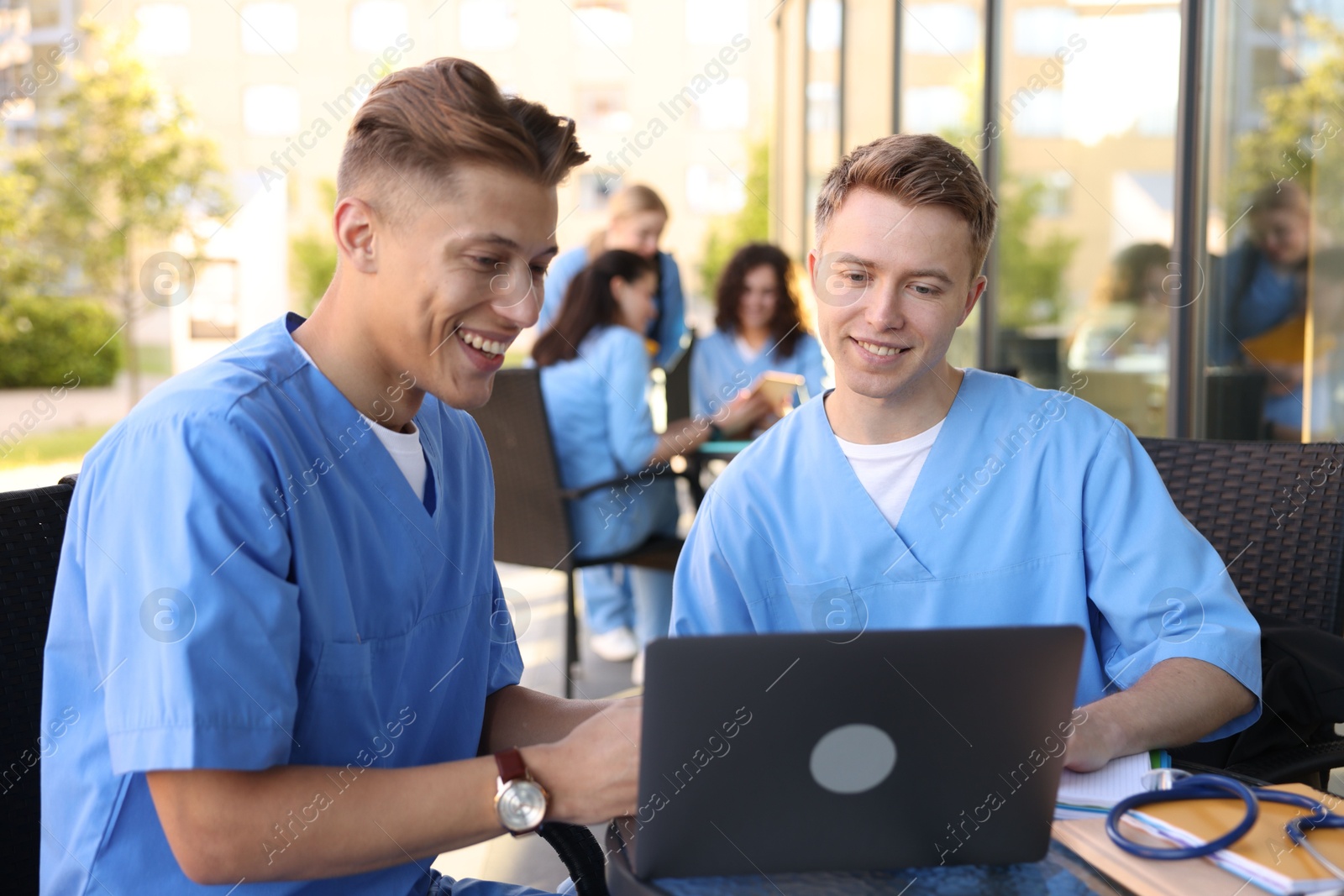 Medical students studying together in outdoor cafe, selective focus Photo of Medical students studying together in outdoor cafe, selective focus