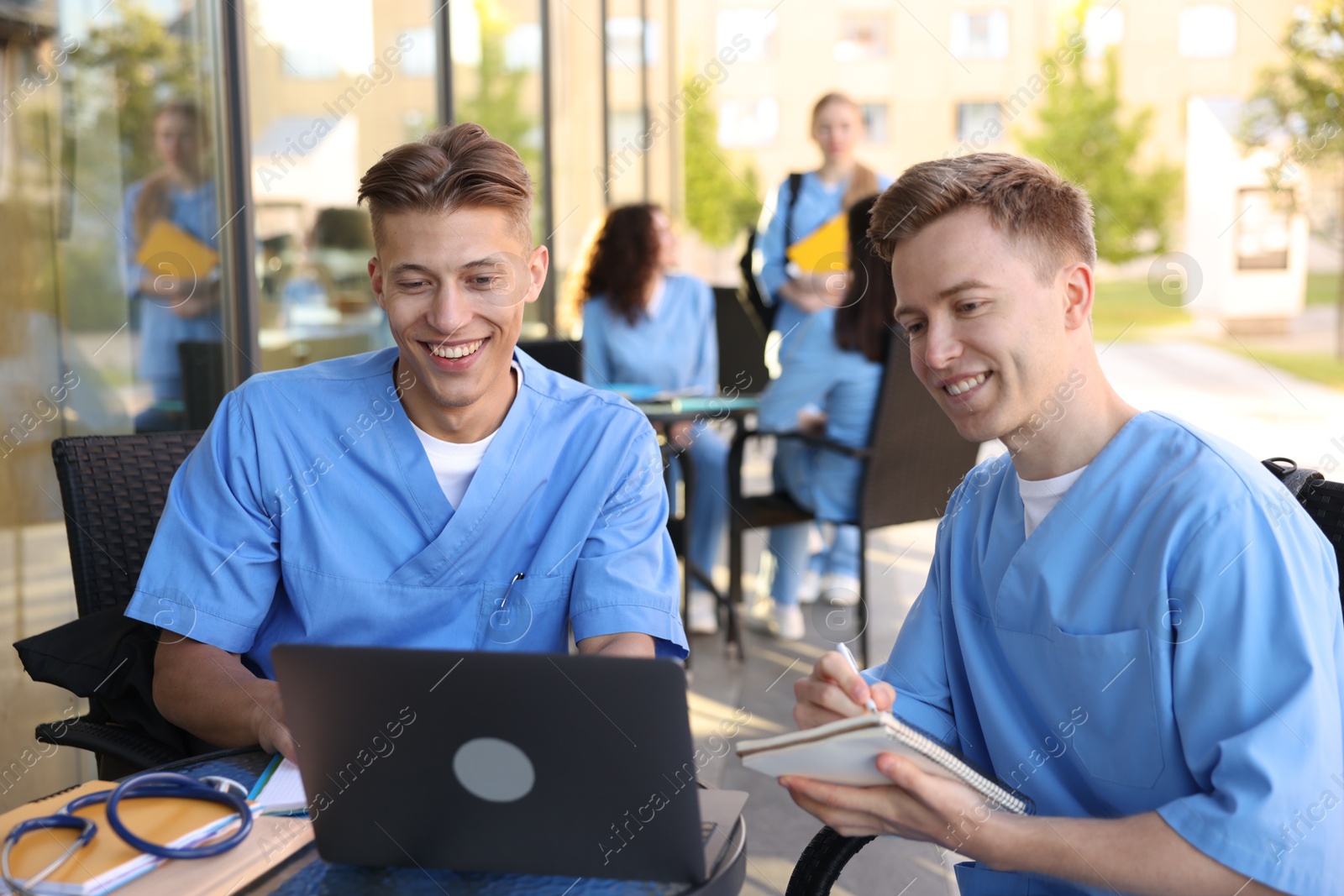 Medical students studying together in outdoor cafe, selective focus Photo of Medical students studying together in outdoor cafe, selective focus