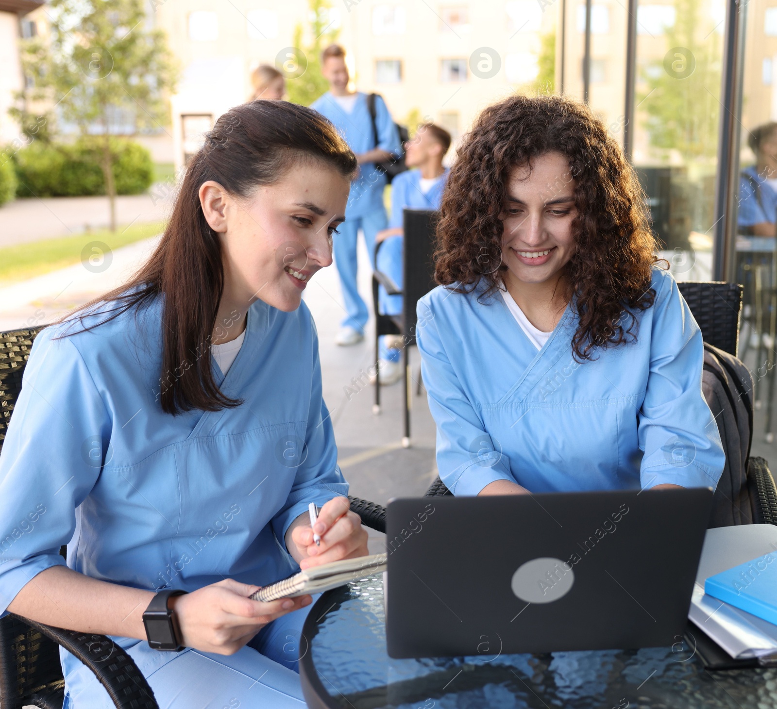 Medical students studying together in outdoor cafe, selective focus Photo of Medical students studying together in outdoor cafe, selective focus