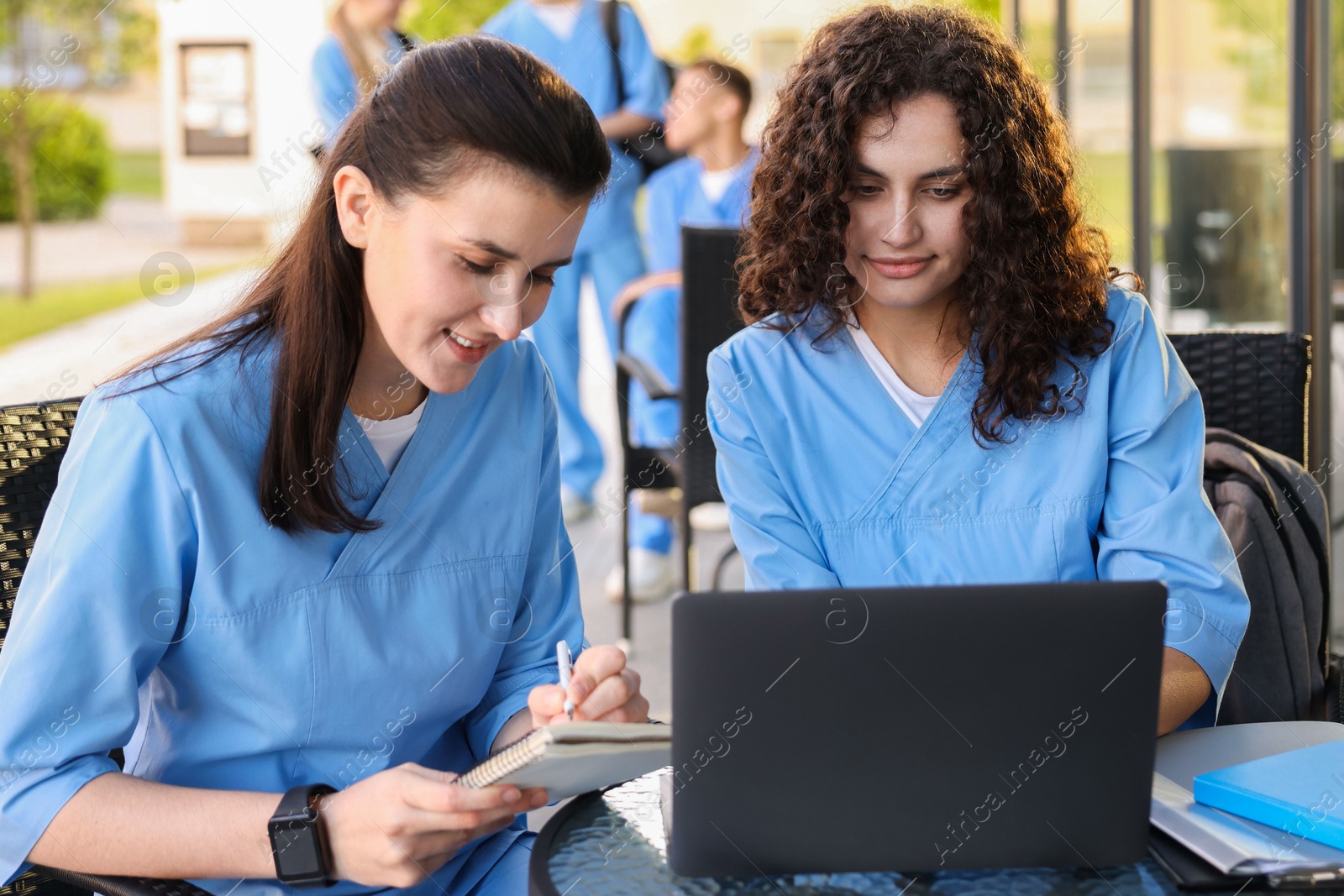 Medical students studying together in outdoor cafe, selective focus Photo of Medical students studying together in outdoor cafe, selective focus