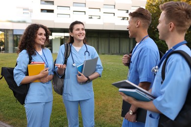 Photo of Group of medical students in uniforms near building outdoors