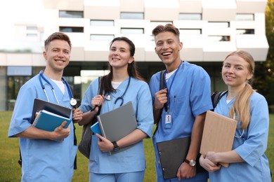 Photo of Group of medical students in uniforms near building outdoors