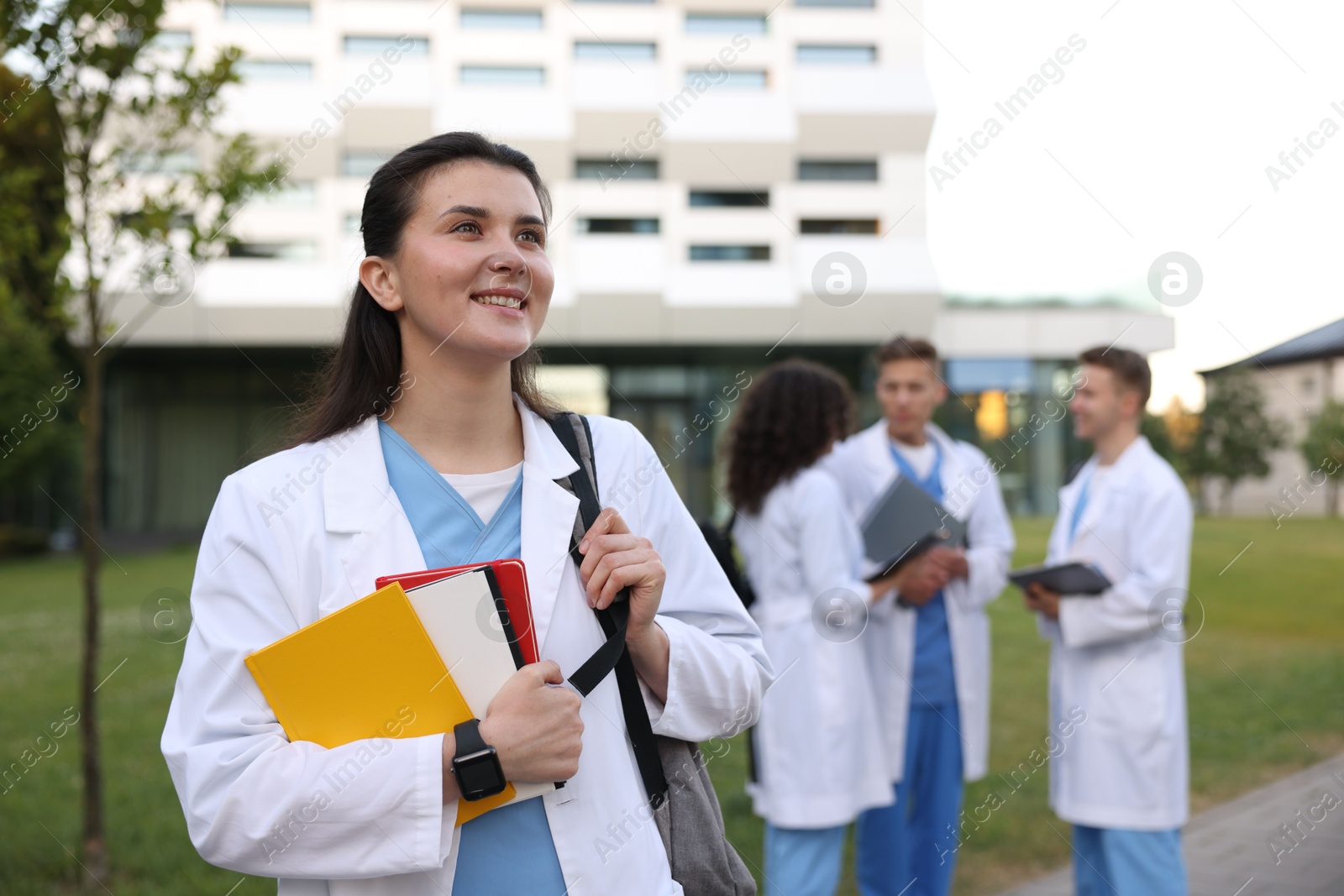 Medical student in uniform with notebooks outdoors, selective focus Photo of Medical student in uniform with notebooks outdoors, selective focus