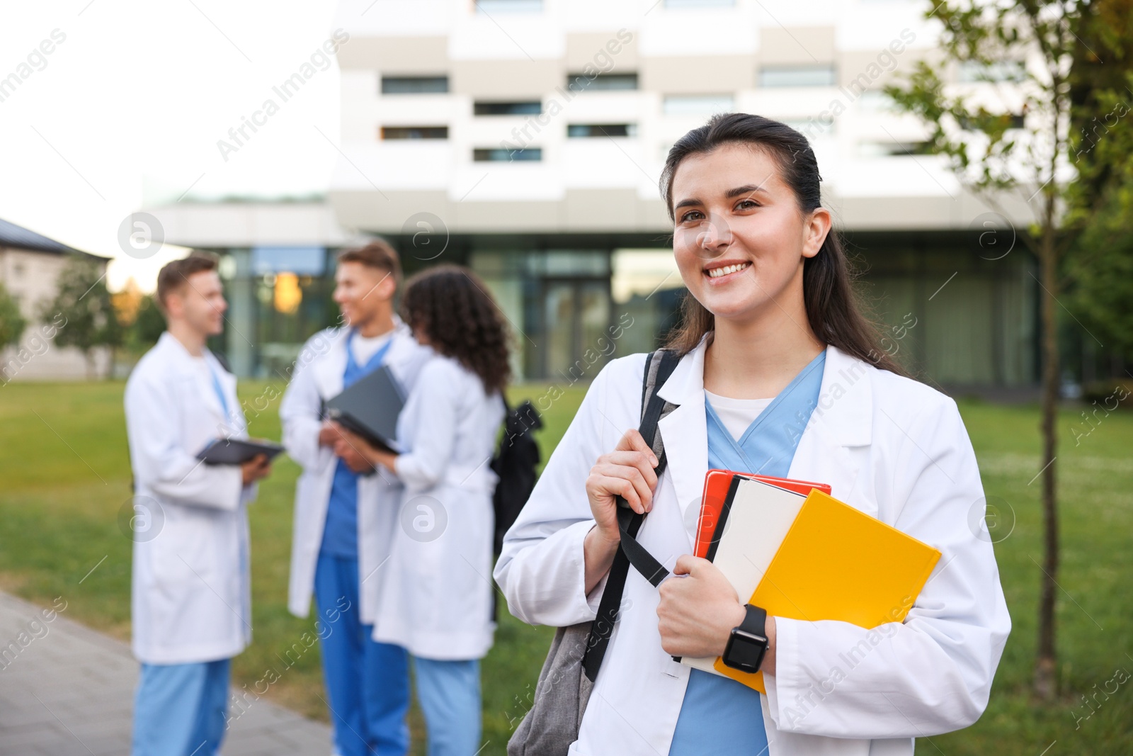 Medical student in uniform with notebooks outdoors, selective focus Photo of Medical student in uniform with notebooks outdoors, selective focus