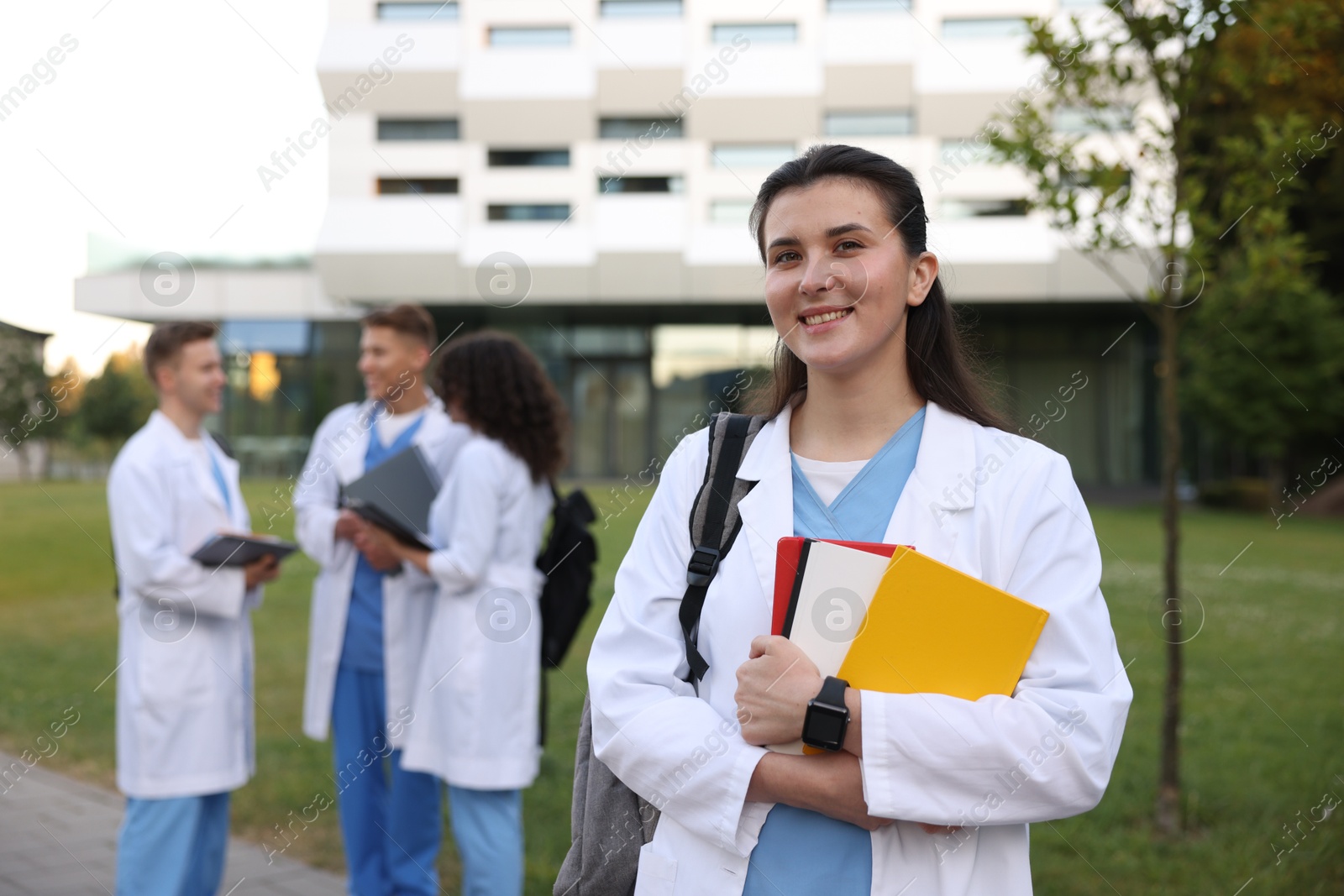 Medical student in uniform with notebooks outdoors, selective focus Photo of Medical student in uniform with notebooks outdoors, selective focus