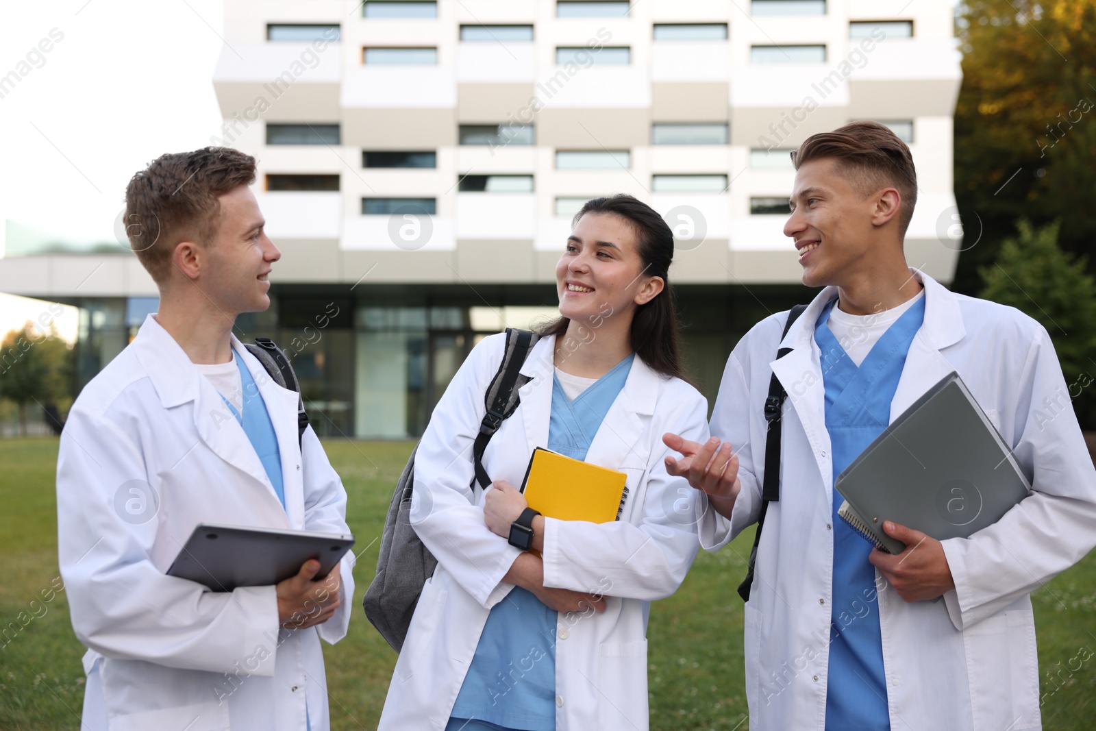 Photo of Medical students in uniforms near building outdoors