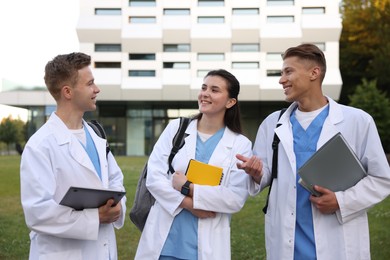 Photo of Medical students in uniforms near building outdoors