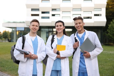 Photo of Medical students in uniforms near building outdoors