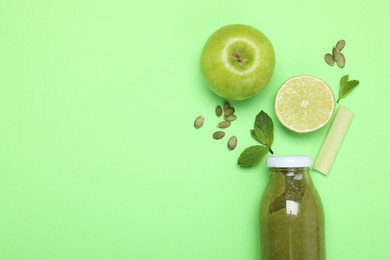 Photo of Superfood. Tasty smoothie in glass bottle and ingredients on green background, flat lay. Space for text