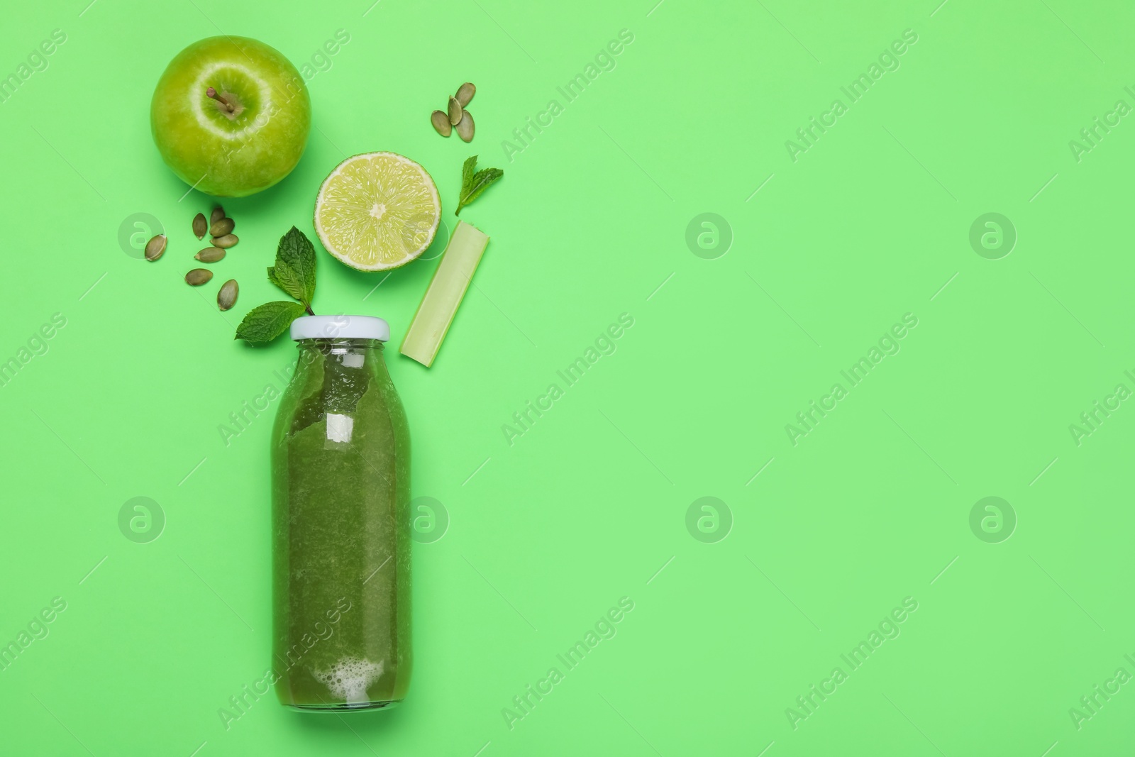 Superfood. Tasty smoothie in glass bottle and ingredients on green background, flat lay. Space for text Photo of Superfood. Tasty smoothie in glass bottle and ingredients on green background, flat lay. Space for text