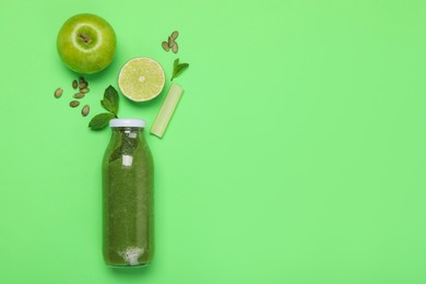 Photo of Superfood. Tasty smoothie in glass bottle and ingredients on green background, flat lay. Space for text