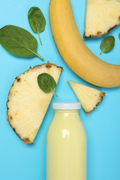 Photo of Superfood. Tasty smoothie in glass bottle and ingredients on light blue background, flat lay
