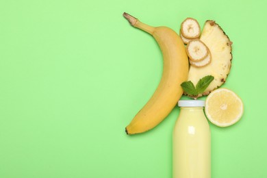 Photo of Superfood. Tasty smoothie in glass bottle and ingredients on green background, flat lay. Space for text