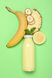 Photo of Superfood. Tasty smoothie in glass bottle and ingredients on green background, flat lay