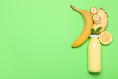 Photo of Superfood. Tasty smoothie in glass bottle and ingredients on green background, flat lay. Space for text