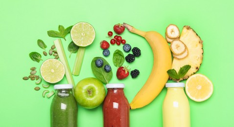 Photo of Superfood. Tasty smoothies in glass bottles and ingredients on green background, flat lay