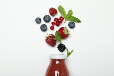 Photo of Superfood. Tasty smoothie in glass bottle and ingredients on white background, top view
