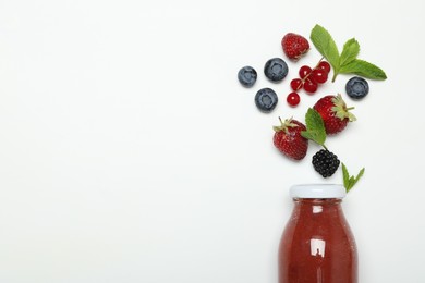 Photo of Superfood. Tasty smoothie in glass bottle and ingredients on white background, top view. Space for text