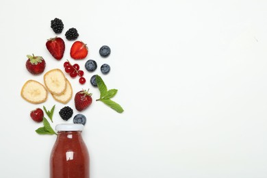 Photo of Superfood. Tasty smoothie in glass bottle and ingredients on white background, top view. Space for text