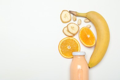 Photo of Superfood. Tasty smoothie in glass bottle and ingredients on white background, top view. Space for text