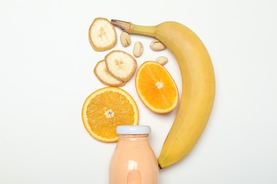 Photo of Superfood. Tasty smoothie in glass bottle and ingredients on white background, top view