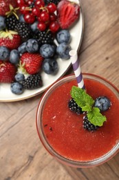Photo of Superfood. Tasty smoothie in glass and ingredients on wooden table, flat lay
