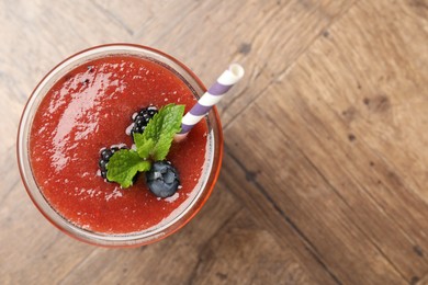 Photo of Superfood. Tasty smoothie in glass on wooden table, top view. Space for text