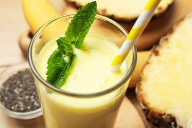 Photo of Superfood. Tasty smoothie in glass and ingredients on table, closeup
