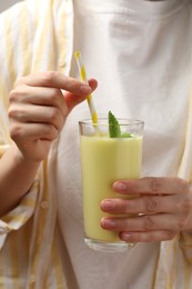 Photo of Superfood. Woman with glass of tasty smoothie, closeup