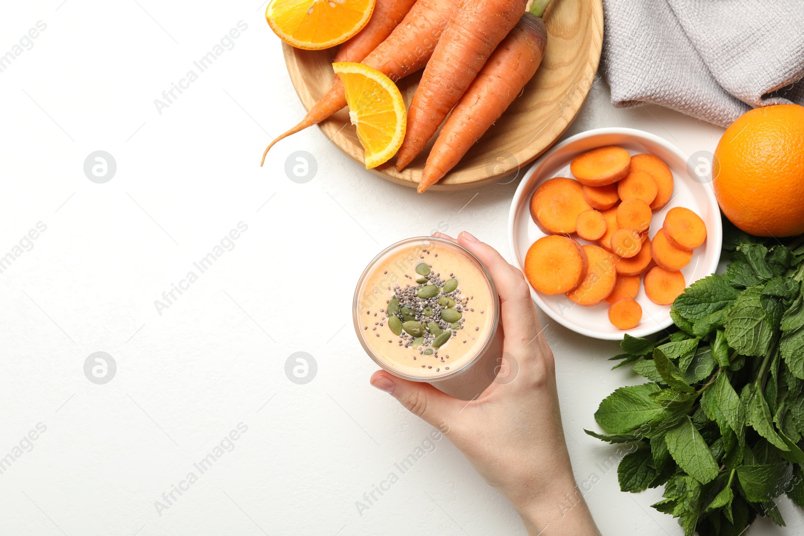 Superfood. Woman with tasty smoothie and ingredients at white table, top view. Space for text Photo of Superfood. Woman with tasty smoothie and ingredients at white table, top view. Space for text