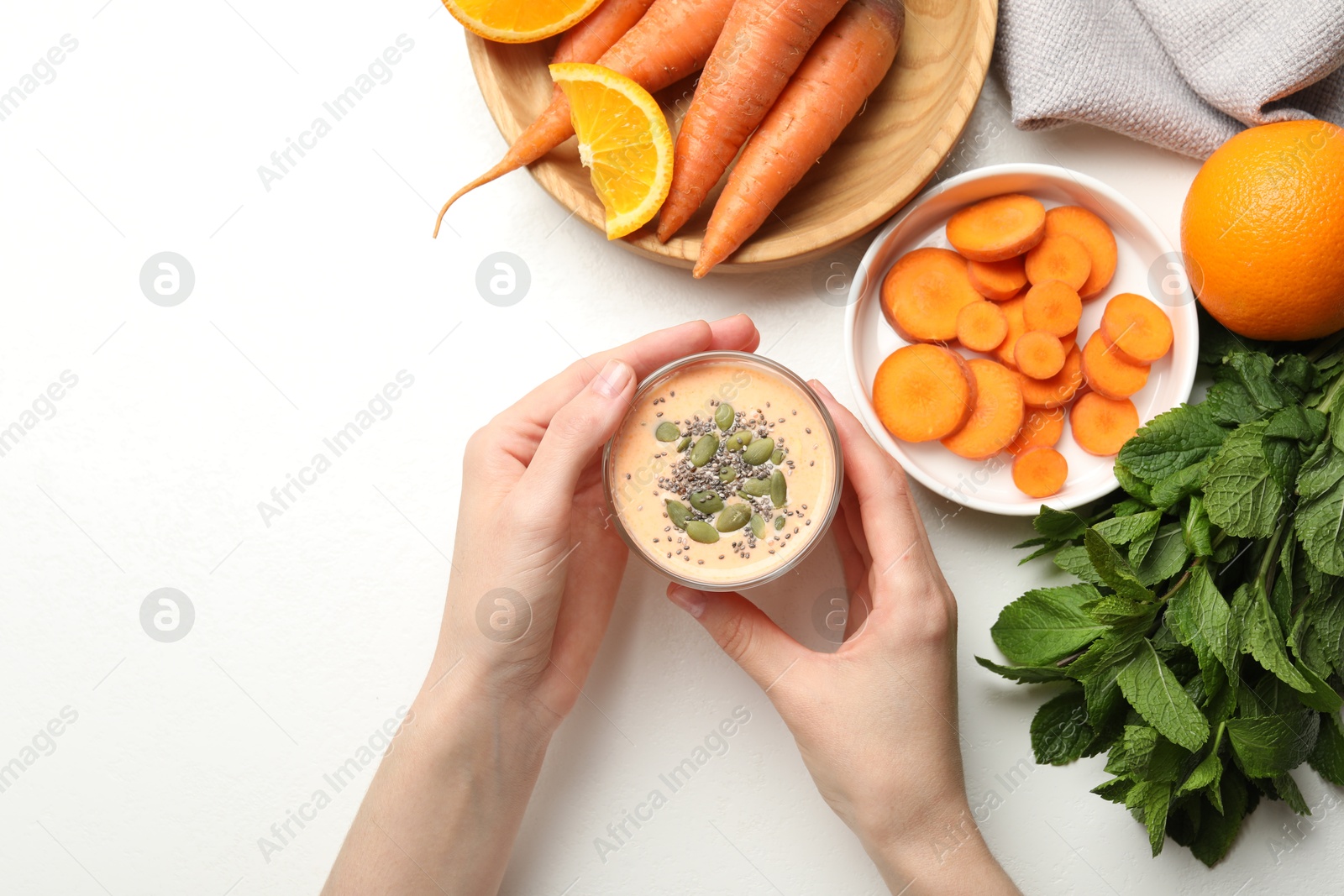 Superfood. Woman with tasty smoothie and ingredients at white table, top view Photo of Superfood. Woman with tasty smoothie and ingredients at white table, top view