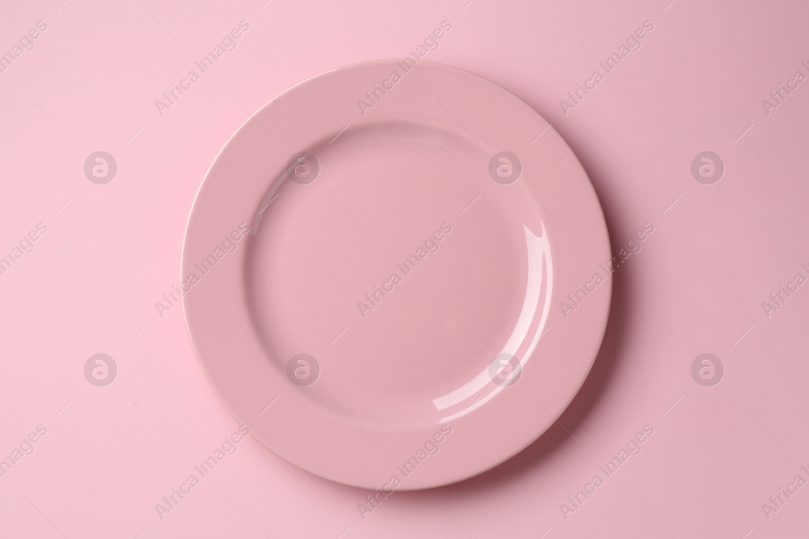 Stylish plate on pink background, top view Photo of Stylish plate on pink background, top view