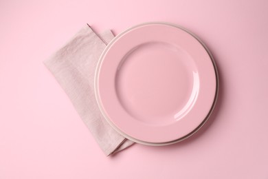 Photo of Stylish plates and napkin on pink background, top view