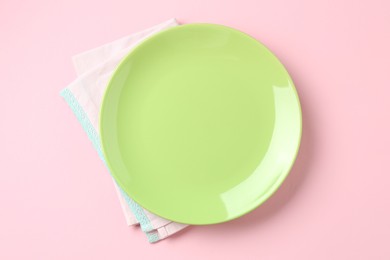 Photo of Stylish plate and napkin on pink background, top view