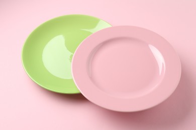 Photo of Two stylish plates on pink background, closeup
