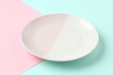 Photo of One stylish plate on color background, closeup