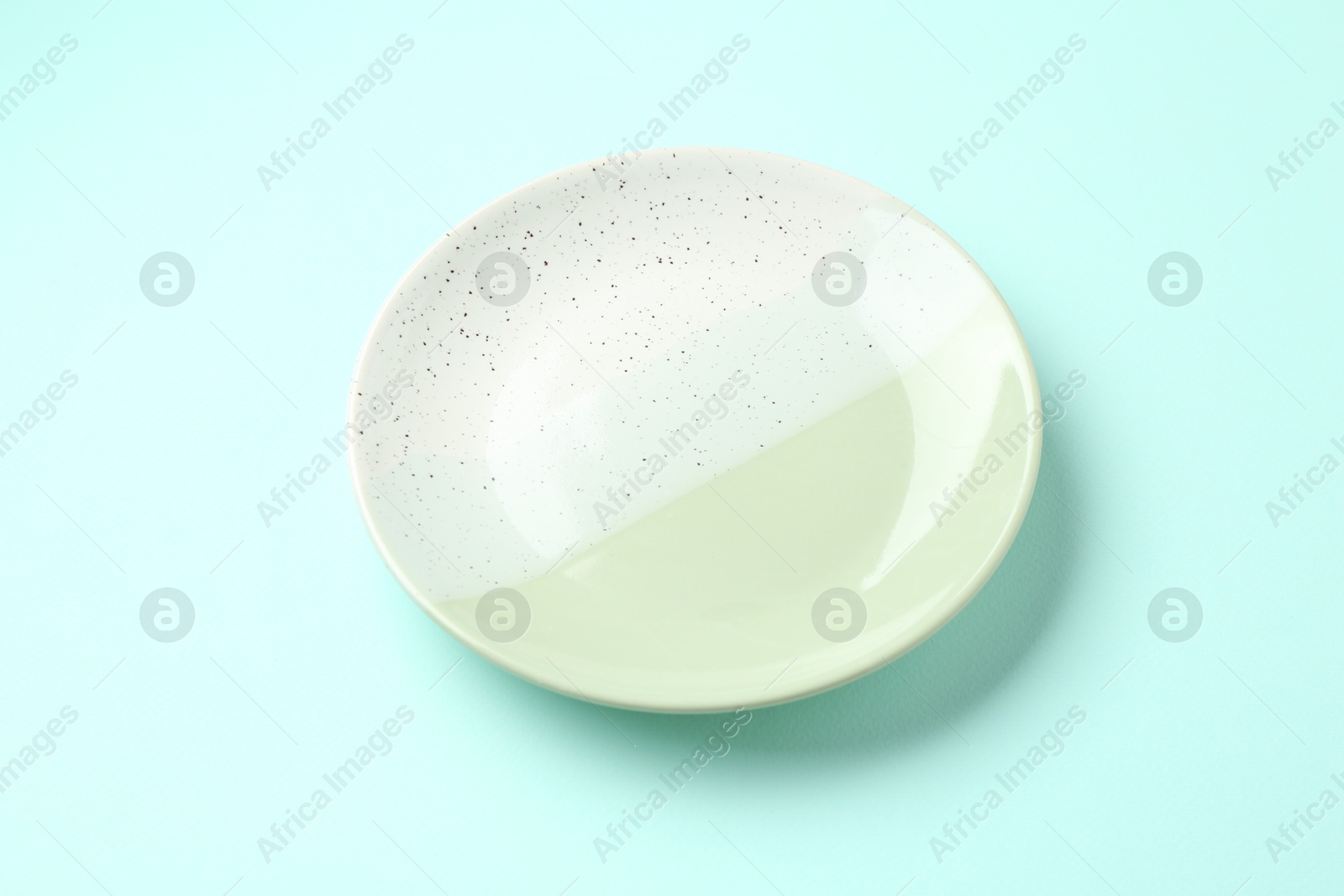Stylish plate on light blue background, above view Photo of Stylish plate on light blue background, above view