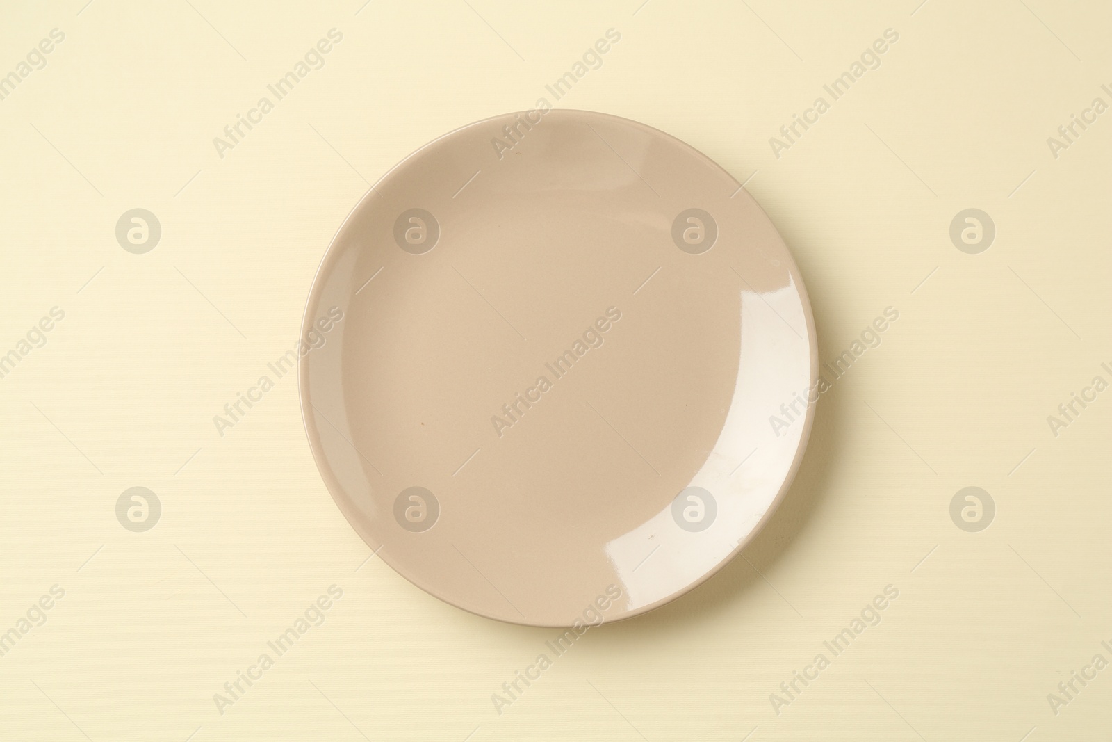 Stylish plate on beige background, top view Photo of Stylish plate on beige background, top view