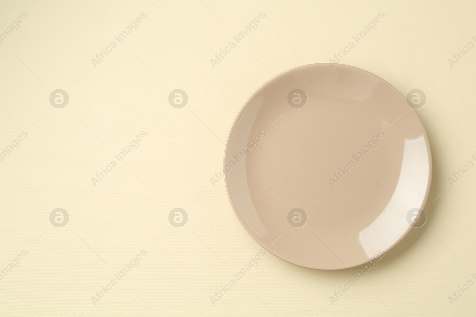 Stylish plate on beige background, top view. Space for text Photo of Stylish plate on beige background, top view. Space for text