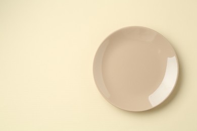 Photo of Stylish plate on beige background, top view. Space for text
