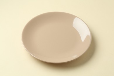 Photo of One stylish plate on beige background, closeup