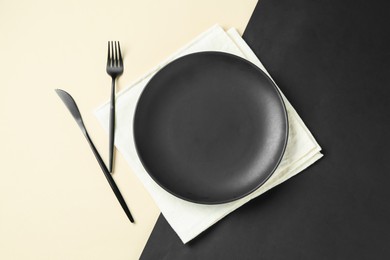 Photo of Stylish plate, cutlery and napkin on color background, flat lay